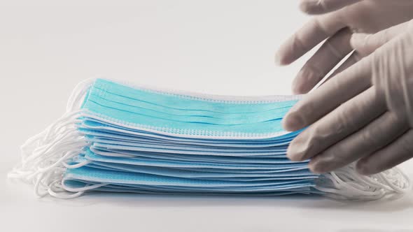Nurses' Hands Remove a Stack of Medical Masks From a White Sterile Surface. Medical Mask Closeup on alt