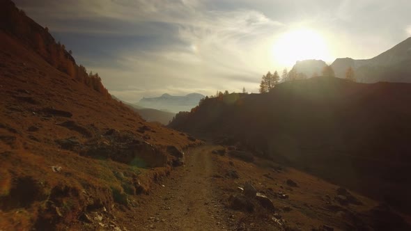 POV Walking on Fall Path to Woods Valley and Snowy Mounts at Sunset with Sun Flare alt