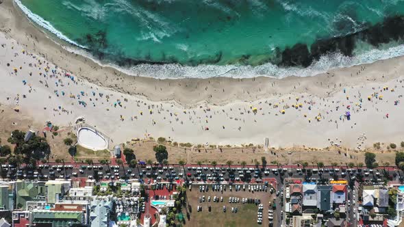 Beautiful top down look Camps Bay beach and the very busy main street down below