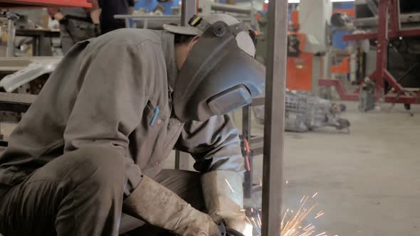 Workman In Workshop. Welding Process. A Welder In Helmet Doing His Job. 