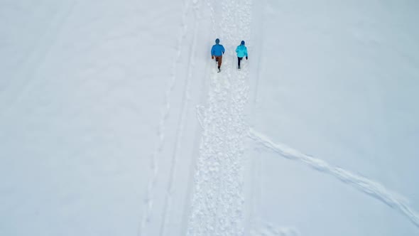 Couple walking on a snowy landscape during winter 4k