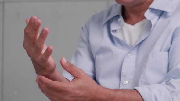 An elderly man's hand is trembling because of Parkinson's disease. alt