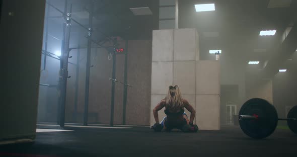 A Woman Performs push-UPS with Dumbbells. Burpee with Weight. The Jerk of the Dumbbells Over Your alt