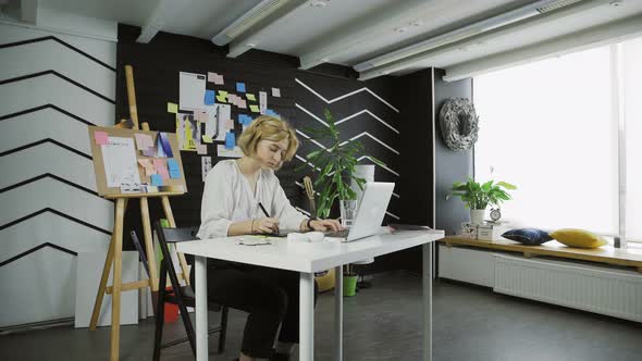 Young Woman Graphic Designer Using Graphics Tablet alt