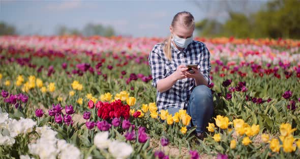 Female Agronomist Wearing Protective Mask and Taking Photo at Farm. alt