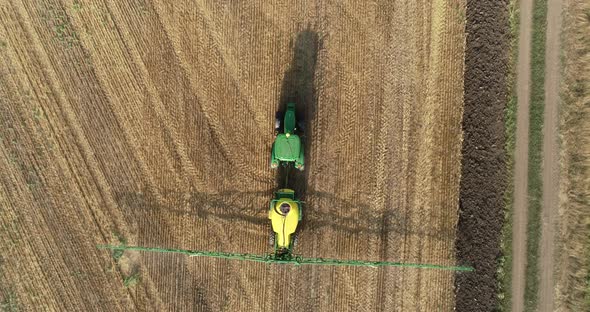 Top down view of farming tractor spraying on field. Protection of plants. alt