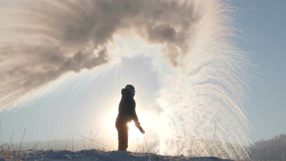 Silhouette of a Man Pouring Boiling Water in the Cold. Experiment with Hot Water.