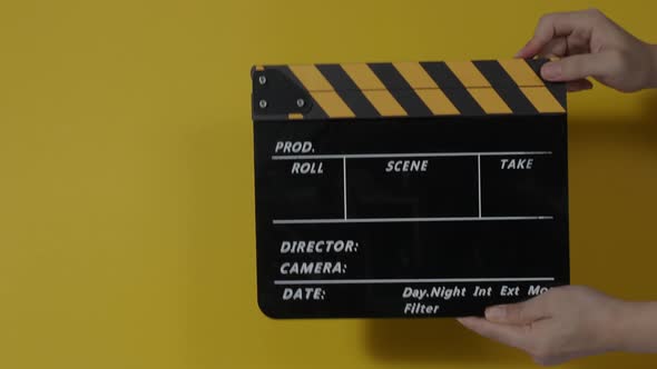 Movie slate or clapperboard hitting. Close up hand holding empty film slate and clapping it. Open