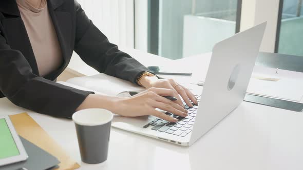 Closeup hands of young woman typing keyboard on laptop computer in the office. alt