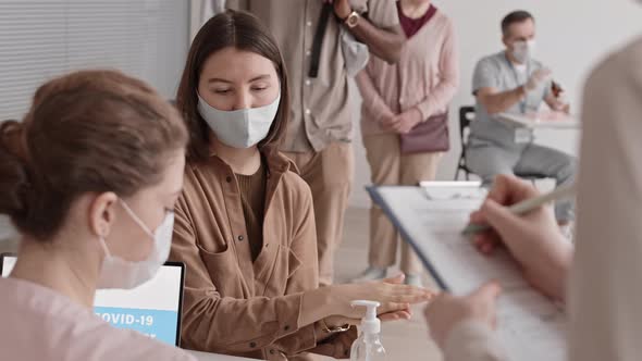 Unrecognizable Medic Measuring Temperature of Visitors alt