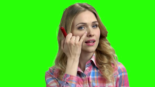 Charming Girl Puts on Makeup on the Green Screen alt