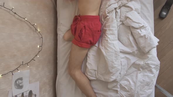 Man with Amputated Leg Tosses and Turns in Bed at Home alt