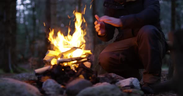 Man Lights a Campfire Outdoors in the Forest
