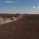 Car Moving on Dirt Road Leading Through Barren Volcanic Plain - VideoHive Item for Sale