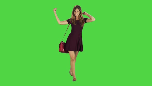 Casual Young Woman Dances and Goofing Around While Walking Over a Green Screen alt