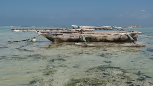 Old Dry African Fishing Rowboat Stranded in Sand on Beach at Low Tide Zanzibar alt