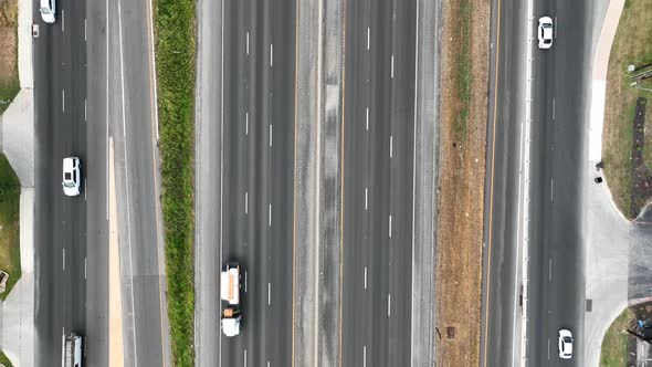 Overhead shot of busy multiple-lane highways and merging vehicles in America. Transportation and tru alt