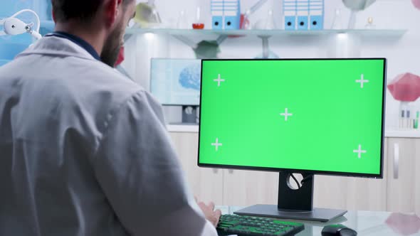Zoom in Shot on Doctor Typing on Green Screen Computer alt