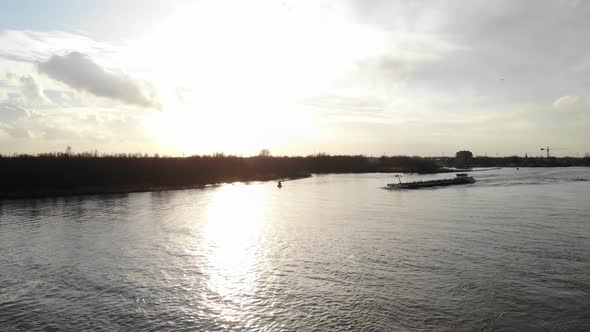A Barge Ship Traveling Across Calm Lake During Sundown In Oude Maas River Near Zwijndrecht, Netherla alt
