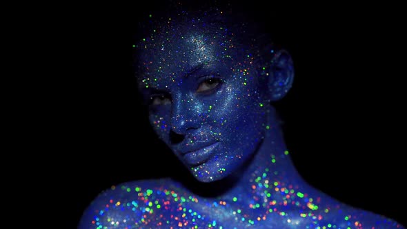 Portrait of Beautiful Woman with Blue Sparkles on Her Face