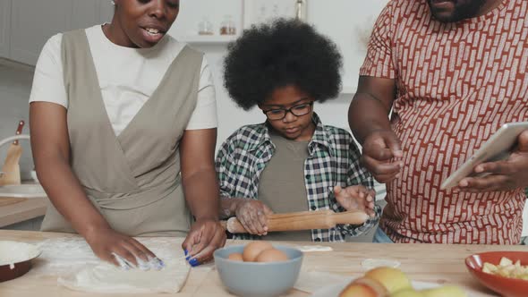African American Boy Making Apple Pie with Parents at Home alt