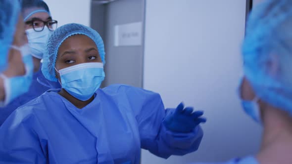 Diverse surgeons wearing surgical caps and face masks discussing x ray alt