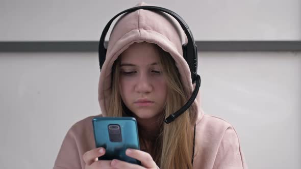 Teen Girl Holding Phone Obsessed with Smartphone Social Media Apps Sitting Alone at Home