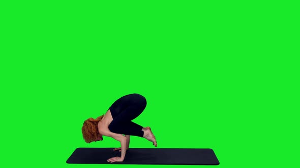 Sporty Woman Standing on Hands During Yoga Exercises Against Green Screen