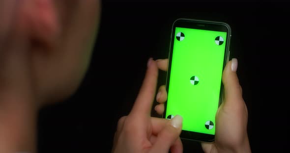 Woman Using Mobile App on Green Screen Phone Swipes to the Left