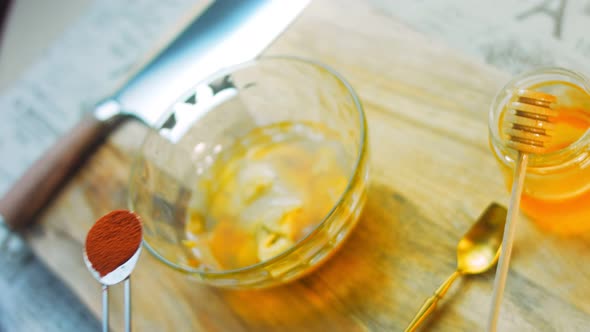 The Cook Pours a Tablespoon of Paprika Over the Ingredients for the Honey and Mustard Sauce alt
