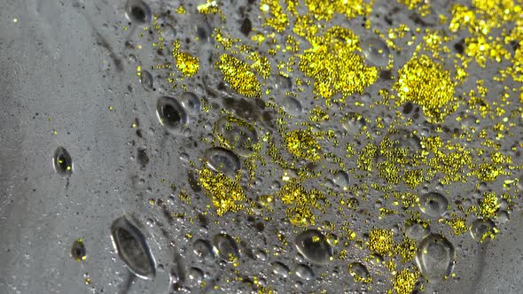 Macro Close Up Shot Of Golden Wet Glitter. Golden Space Glittering Particle Background.  alt