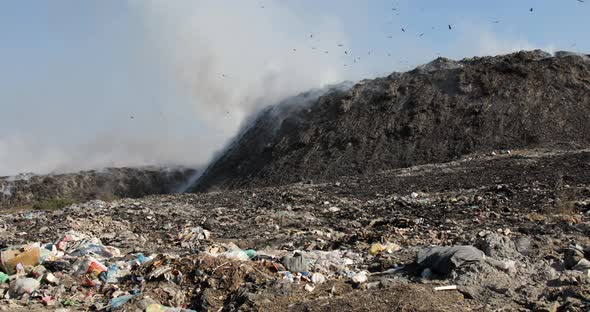 Landfill with burning trash piles alt