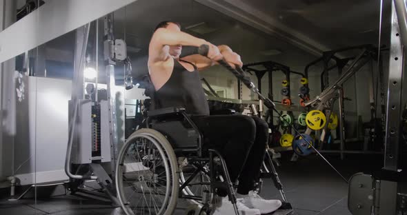 Disabled man in a wheelchair in the gym. Gym workout for the disabled persons.