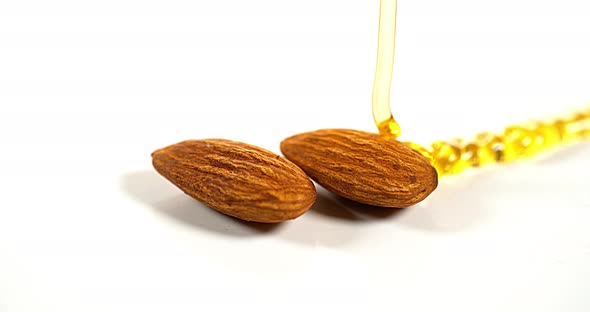 Honey Flowing on Almonds against White Background, Slow Motion 4K alt