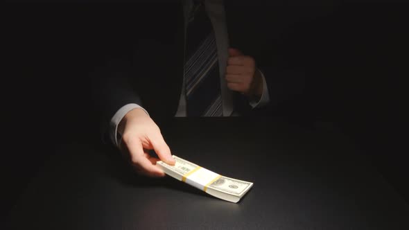 Bribe: Businessman waits and takes out a money from a pocket of a suit (US dollars)
