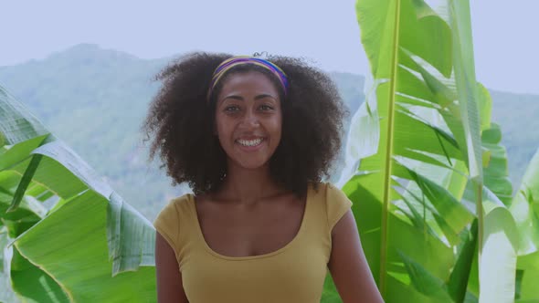 Charming Multiethnic Woman in Bright Yellow Dress Cute Smiles Looking at the Camera Standing Against alt