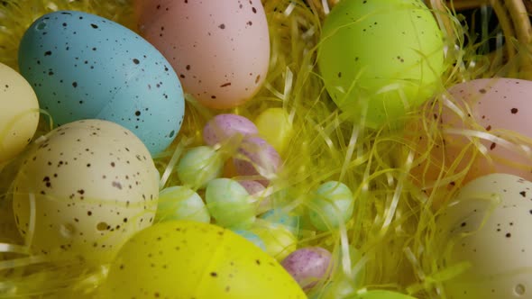 Rotating shot of Easter decorations and candy in colorful Easter grass  alt