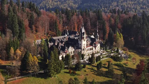 Aerial drone view of The Peles Castle in Romania. Castle with gardens in Carpathians, forest around  alt