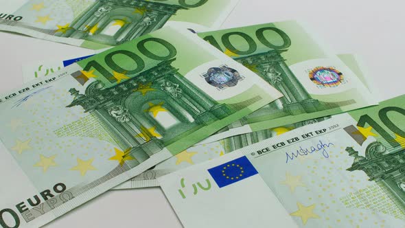 Recalculation of money. EU euro banknotes are falling on a white background. One hundred euro