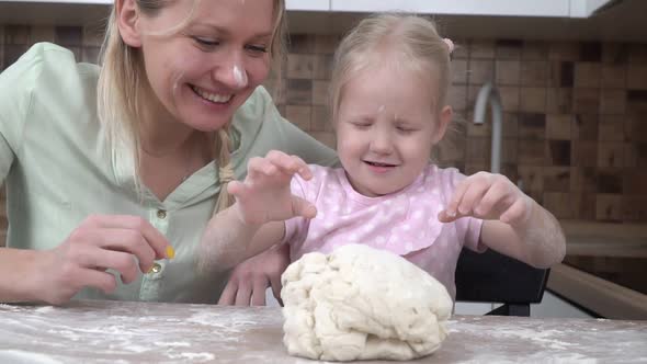 Happy Family Mom and Daughter are Preparing Pastries From the Dough in the Kitchen alt