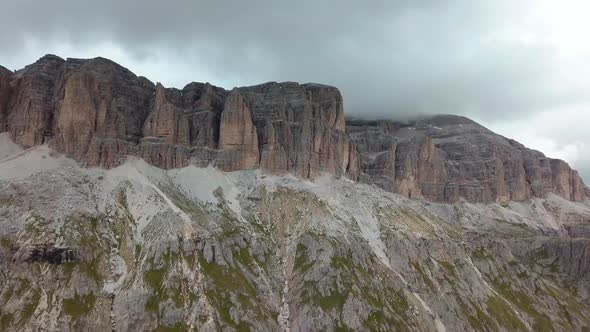 Dolomite mountain rock formation in northern Italy cloudy skies in a winter day, Aerial drone right alt
