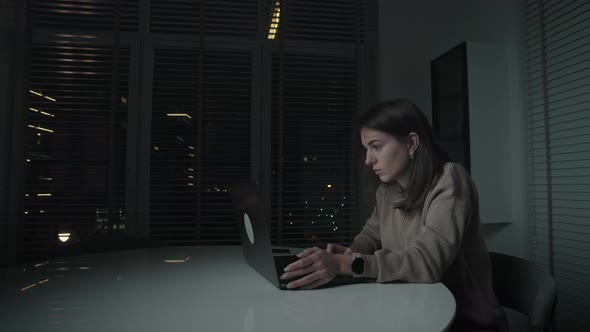 Woman working remotely from home at night.