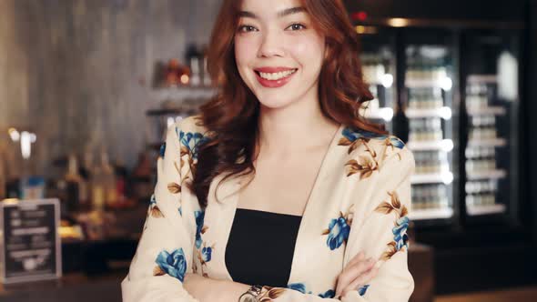 Business owner attractive young mixed race woman in apron hanging we're open sign alt