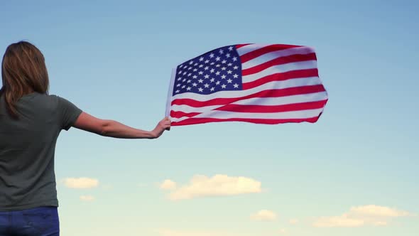 Woman Holds Usa Flag Against Blue Sky alt