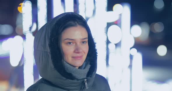 Beautiful Happy Woman Walks the Street at Night the Lights of Garlands are Lit alt