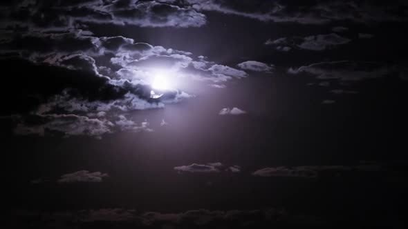 Timelapse of Moon Moves in the Night Sky Through Dark Clouds alt