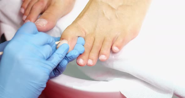 Pedicure Master Cleans Nails From Dry Skin and Dirt on Toes with Wooden Stick alt