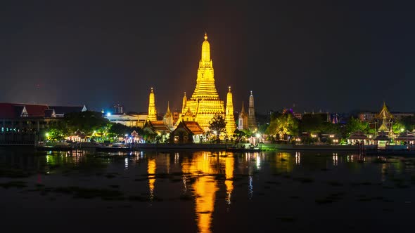 time lapse of Wat Arun Temple with Chao Phraya river at night in Bangkok, Thailand alt