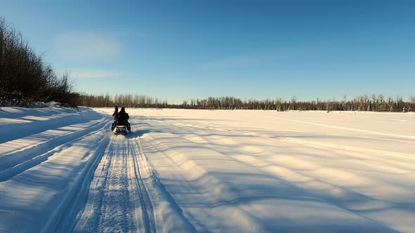 POV View of Two Snowmobile Rides Through the Pine Forest in Slow Motion Footage alt