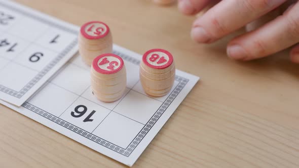 Woman's hand holding a barrel for a game in lotto. alt